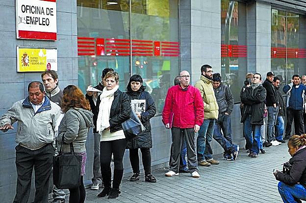 Un grupo de personas guarda cola en una oficina de empleo de Madrid. 