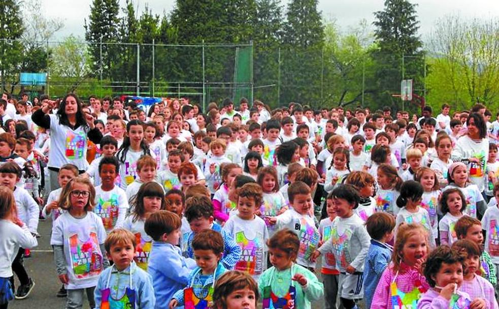 Numeroso grupo de txikis en un acto celebrado en el patio de la ikastola