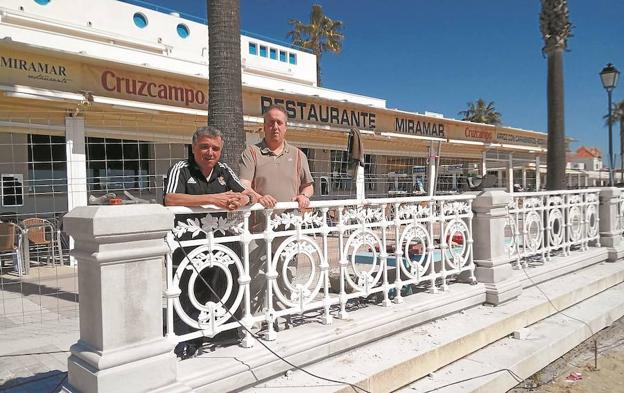 Ignacio Murillo y Pablo Tola posan ante la barandilla de La Concha, colocada en la playa de La Antilla de Lepe.
