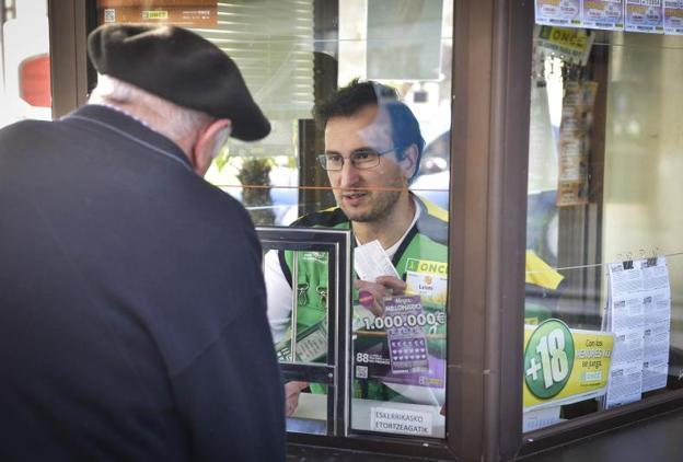 Luis Miguel González atiende a un cliente en su punto fijo de la ONCE en Tolosa.