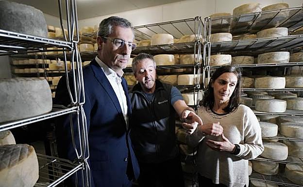 Markel Olano atiende las explicaciones de Joseba y María durante su visita al caserío Gorua Goiena