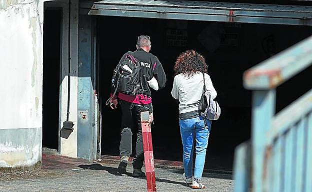 Dos investigadores de la Ertzaintza acceden al interior del garaje situado en la plaza Bizkargi de Azkoitia, donde se encontró calcinado el cuerpo de una mujer. 