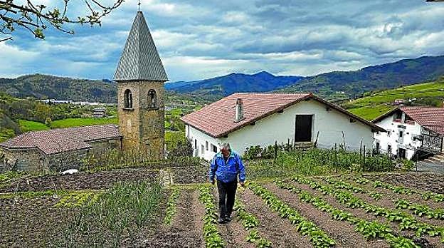 Un vecino de Belauntza, uno de los pueblos pequeños guipuzcoanos que más población ha perdido, recorre su huerta.