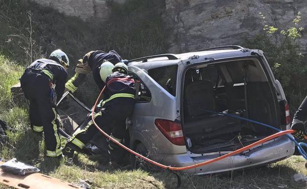 Bomberos intervienen en el vehículo accidentado en la A-1 en Júndiz. 