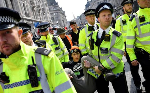 Policías detienen a un manifestante del grupo ecologista Extinction Rebellion en Londres. 