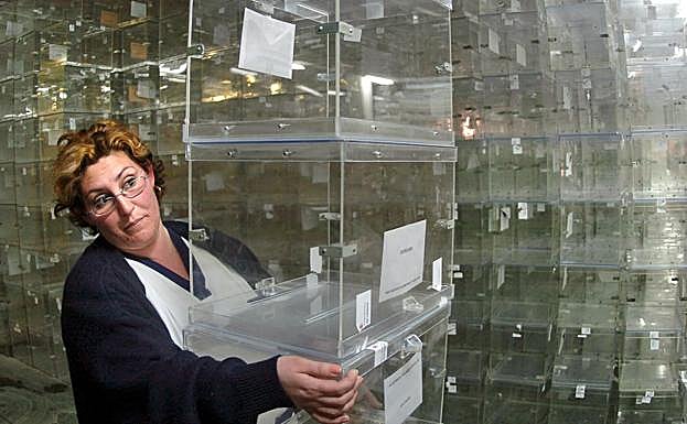 Una empleada del ayuntamiento de Sevilla traslada unas urnas.