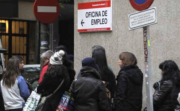 Parados haciendo cola a las puertas de una oficina de empleo.