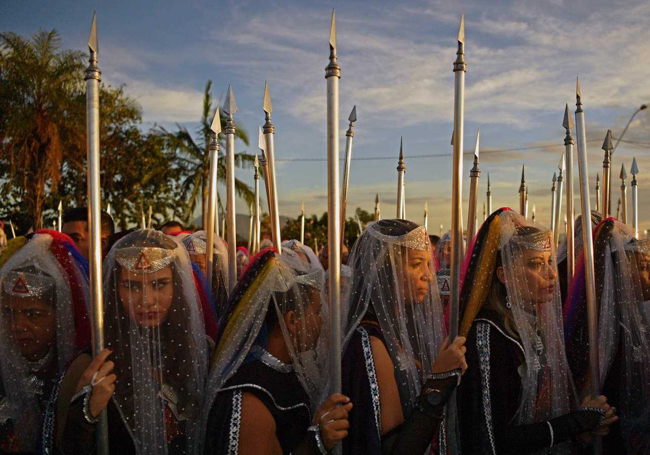 Ninfas, mujeres devotas de la comunidad religiosa de 'Vale do Amanhecer', oran durante su ceremonia más grande del año en el complejo de templos de Vale do Amanhecer, una comunidad a las afueras de Planaltina, a 50 km de la capital brasileña, Brasilia. Esta comunidad ecléctica celebra su ritual más importante del año para honrar a los medios que se comunican con los espíritus buenos y malos. El grupo combina una variedad de prácticas religiosas, incluidas cristianas e hindúes, con símbolos tomados de los incas y mayas, así como una creencia en la vida extraterrestre y los viajes intergalácticos. Con unos 600 templos en todo Brasil, Portugal, Alemania, Japón, Bolivia, Uruguay y los Estados Unidos, el movimiento religioso afirma tener 800,000 miembros.