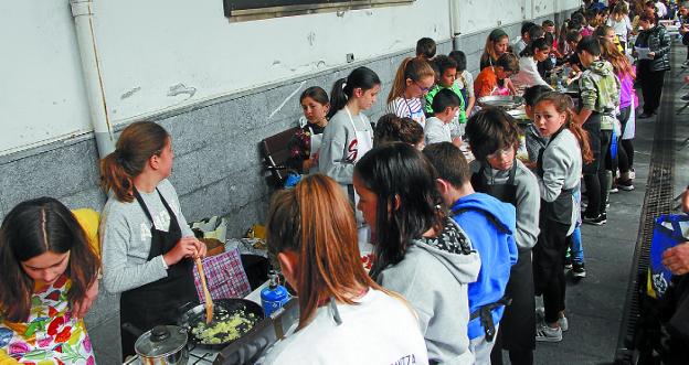 El paseo cubierto se llenó de jóvenes participantes en el concurso de paellas. 