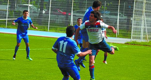 Rubén disputa un balón rodeado de adversarios.