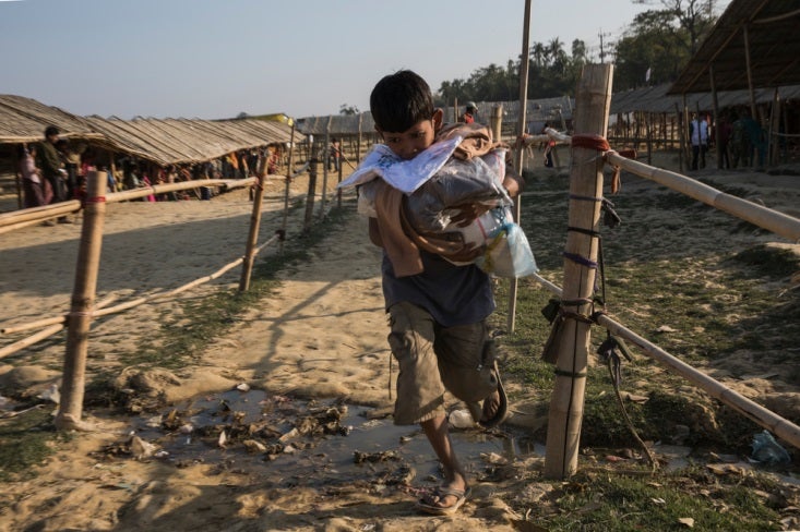 Supervivencia . Tras haber perdido todo, los rohingyas dependen totalmente de la ayuda humanitaria. Un centenar de ONG trabajan en los asentamientos más masificados. Y no solo hace falta comida, refugio o atención primaria; la salud mental también es crucial para que la población pueda sobrellevar las traumáticas experiencias vividas. Un niño corre tras conseguir un saco con ayuda humanitaria en una distribución de comida junto al asentamiento de Nayapara. 