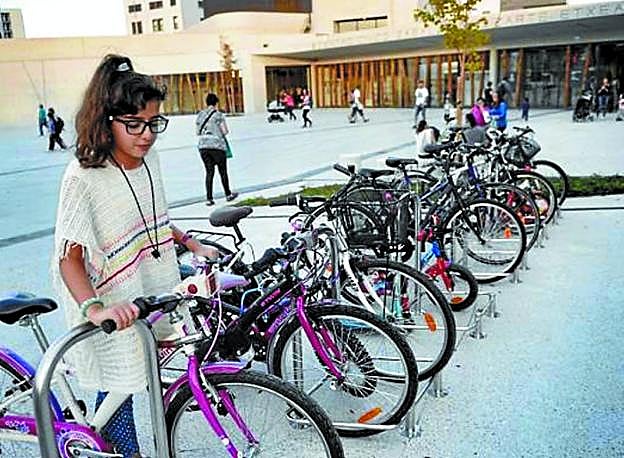 Una joven aparca su bici. 