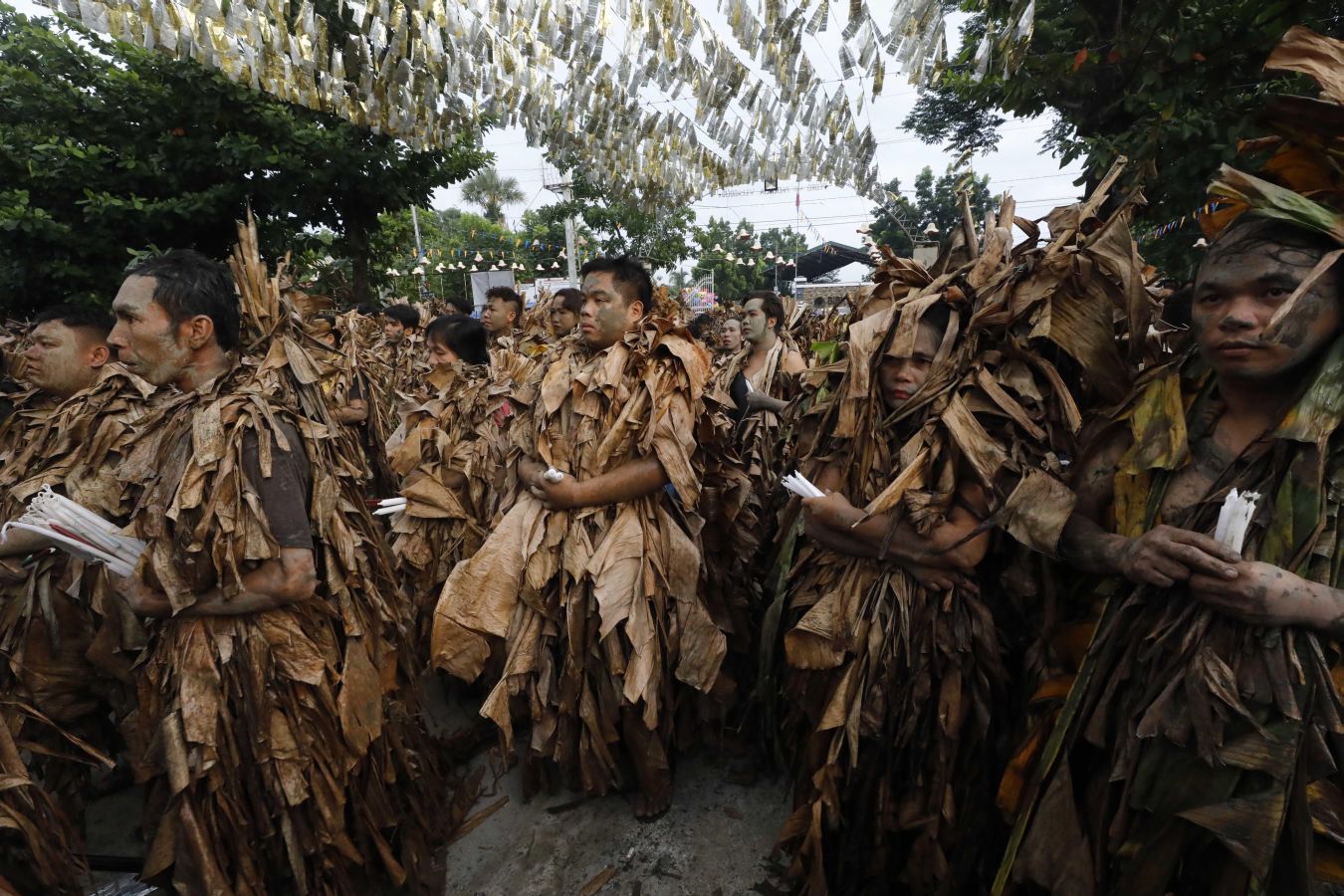 Devotos católicos filipinos de Saint John the Baptist cubiertos de barro y hojas de plátano encienden velas fuera de la Iglesia Parroquial. El ritual de 'Taong Putik' (pueblo de barro) es seguido por una santa misa para conmemorar el día de la fiesta de Saint John the Baptist, mientras los devotos agradecen las oraciones contestadas y esperan una cosecha abundante cada año.