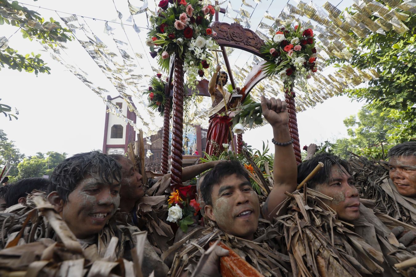 Devotos católicos filipinos de Saint John the Baptist cubiertos de barro y hojas de plátano encienden velas fuera de la Iglesia Parroquial. El ritual de 'Taong Putik' (pueblo de barro) es seguido por una santa misa para conmemorar el día de la fiesta de Saint John the Baptist, mientras los devotos agradecen las oraciones contestadas y esperan una cosecha abundante cada año.