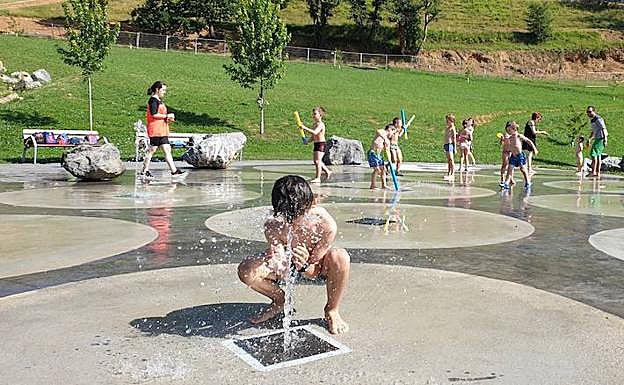Galería. Los más pequeños juegan con el agua para refrescarse en Azpeitia. 