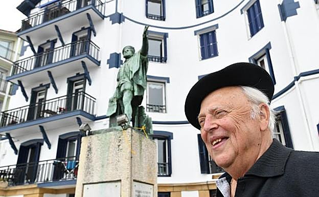 Jon Esnal posa junto a la estatua que trasladó en 1978 del Paseo Nuevo de San Sebastián a su ubicación original en Getaria