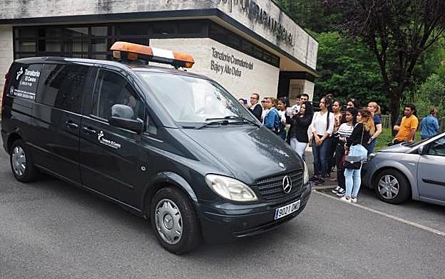 Familiares y amigos de la víctima observan la salida del furgón fúnebre del tanatorio. 