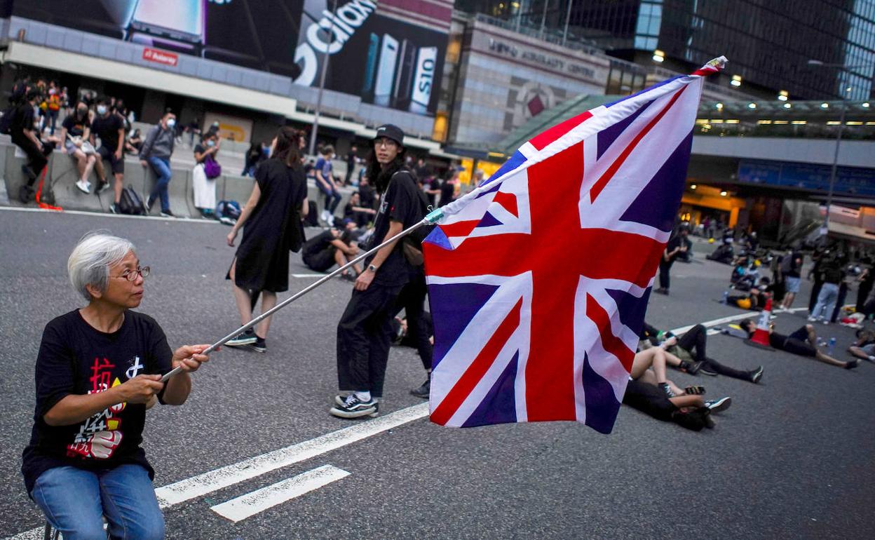 Una mujer sostiene una bandera de Reino Unido durante las protestas en Hong Kong. 