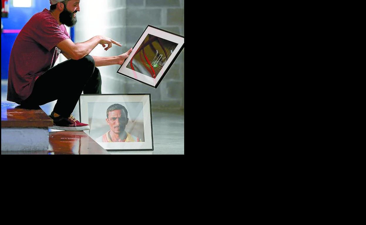 Con sus fotos, en Jareño. Mikel sostiene la foto portada del catálogo. En el suelo, la de un peón caminero paquistaní, emigrante en Omán. 