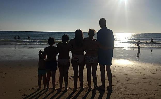Eneko Goia y su familia contemplan una puesta de sol en la playa