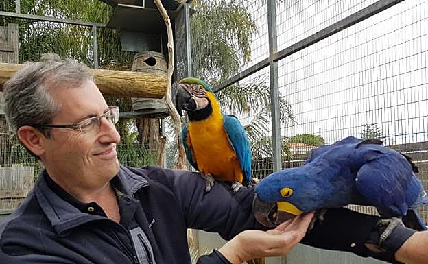 Markel Olano posa junto a unos loros en un parque zoológico en Girona