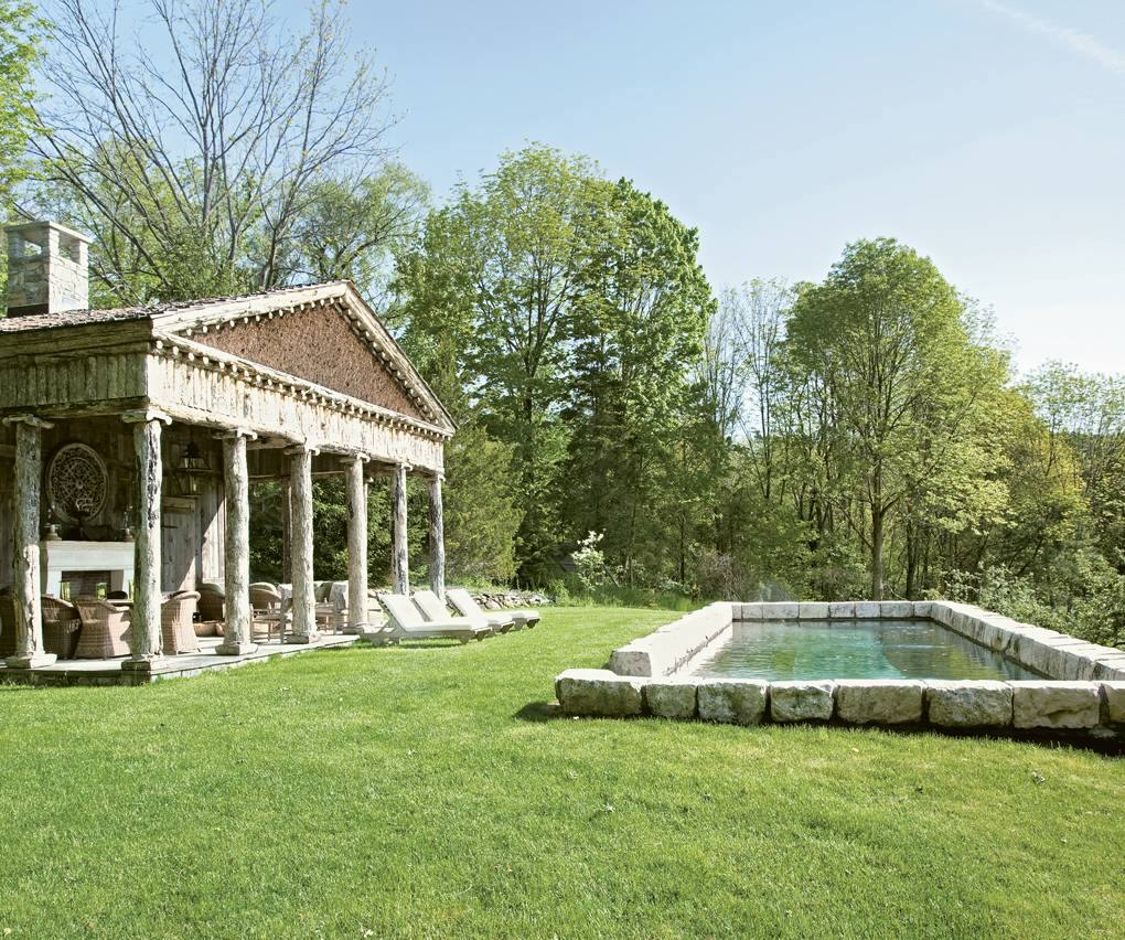 La piscina rústica diseñada por Bunny Williams encima de su casa en Connecticut está inspirada en la arquitectura griega local de Falls Village del renacimiento griego.