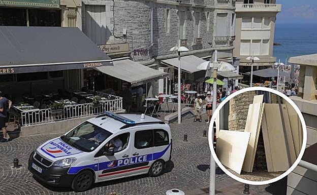 Una furgoneta de la Policía francesa en el centro de Biarritz con los paneles de madera para tapiar comercios.