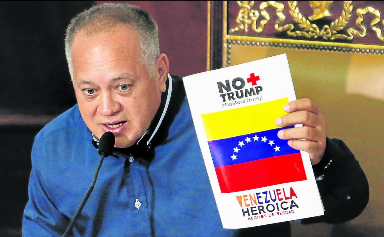 El presidente de la Asamblea Nacional, Diosdado Cabello, sostiene un cartel de rechazo a Trump durante una sesión.