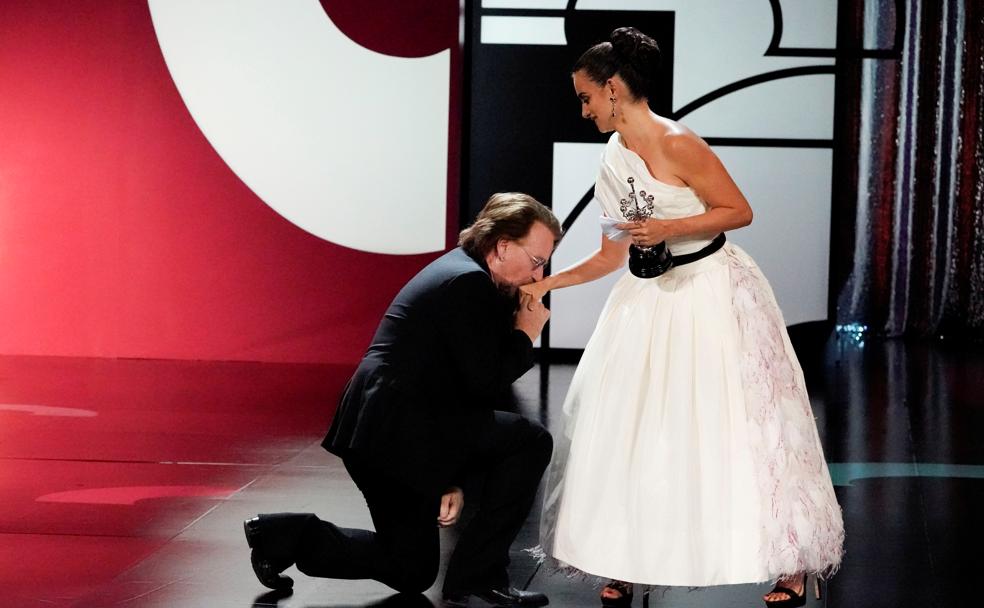 Bono se arrodilla ante Penélope Cruz.