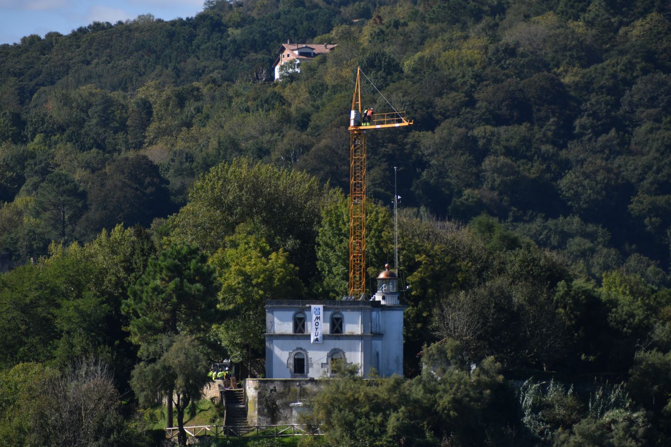 Un helicóptero ha sido el encargado de trasladar, por piezas, la grúa para la obra del Faro.