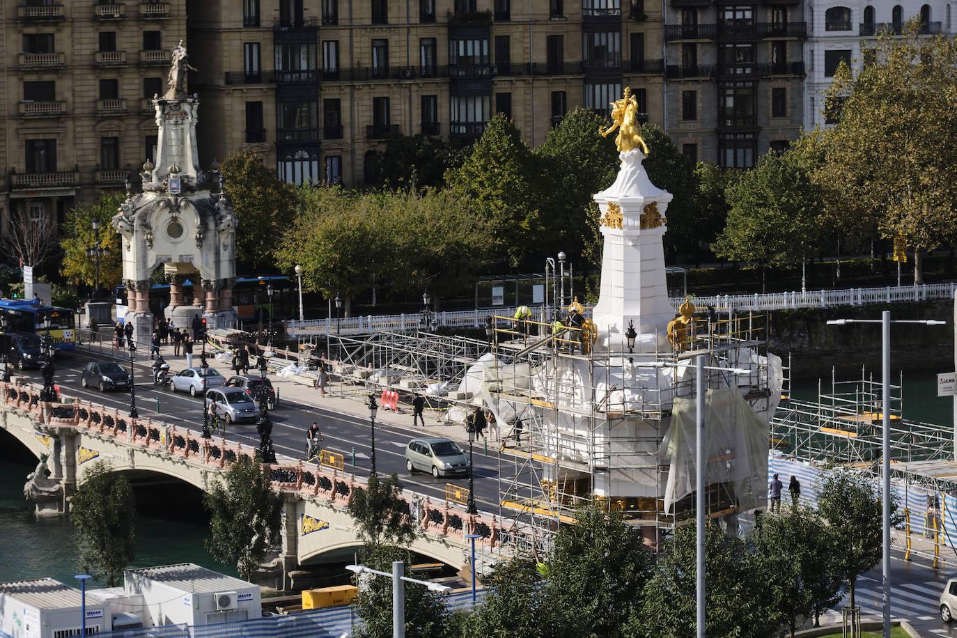 El primero de los cuatro obeliscos restaurados del puente María Cristina de San Sebastián ha comenzado a mostrar todo su esplendor, en contaste con el estado de los aún por rehabilitar