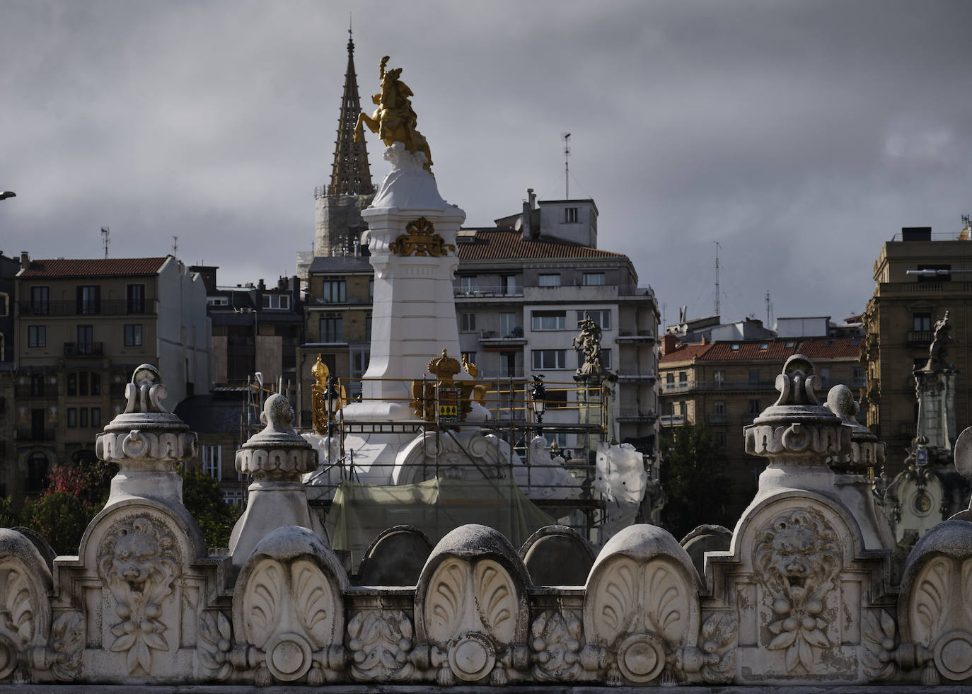 El primero de los cuatro obeliscos restaurados del puente María Cristina de San Sebastián ha comenzado a mostrar todo su esplendor, en contaste con el estado de los aún por rehabilitar