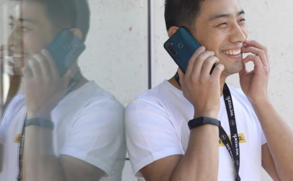 El director del fabricante chino de teléfonos inteligentes, RealMe en Europa, Levi Lee posa con uno de los teléfonos de su compañia.