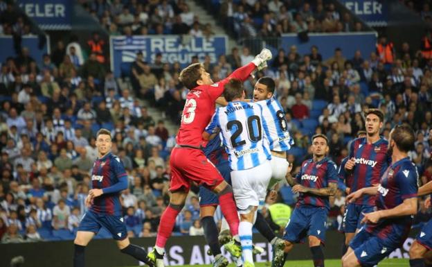 Aitor Fernández sale con los puños ante Monreal y Merino. 