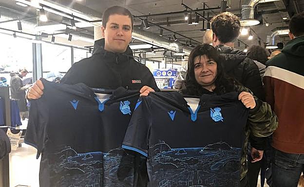 Imagen principal - Aficionados posan con las nuevas camisetas