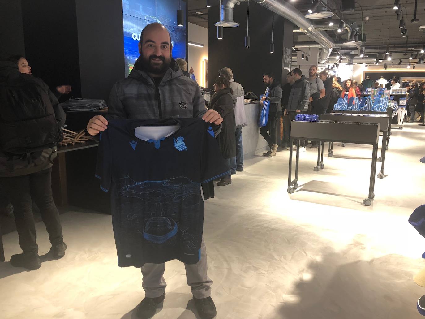 Cientos de aficionados realistas han esperado durante varias horas bajo la lluvia en las tiendas de la Real Sociedad para comprar una elástica