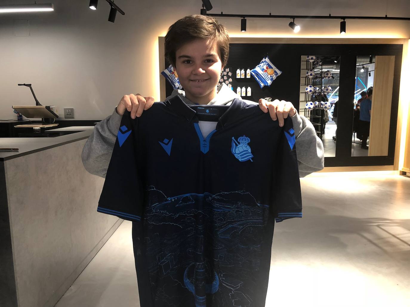 Cientos de aficionados realistas han esperado durante varias horas bajo la lluvia en las tiendas de la Real Sociedad para comprar una elástica