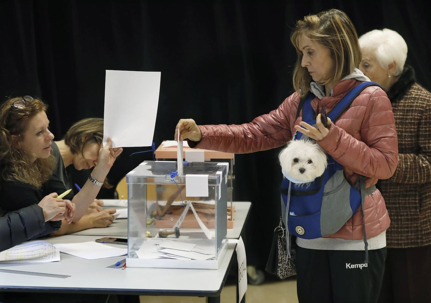 Una mujer vota en un colegio electoral de Barcelona acompañada de su mascota.