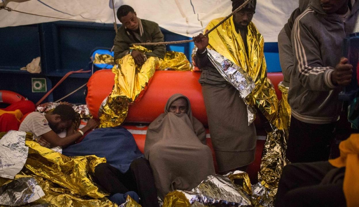 Los hombres se cobijan bajo una lona en la cubierta del 'Aita Mari'. 