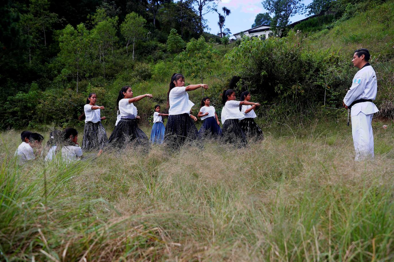 Niñas q'qchí de la aldea Tipulcan en San Pedro Carchá practican taekwondo con su maestro, Danny Coy, en una cancha de tierra en el medio de la aldea. Cada golpe es seguido por un fuerte grito que se resuena en las laderas de la zona montañosa de Alta Verapaz, en el norte de Guatemala. Con cada patada al aire, las niñas de la aldea Tipulcan espantan a los fantasmas de la violencia machista y el acoso que han sufrido en su comunidad. 