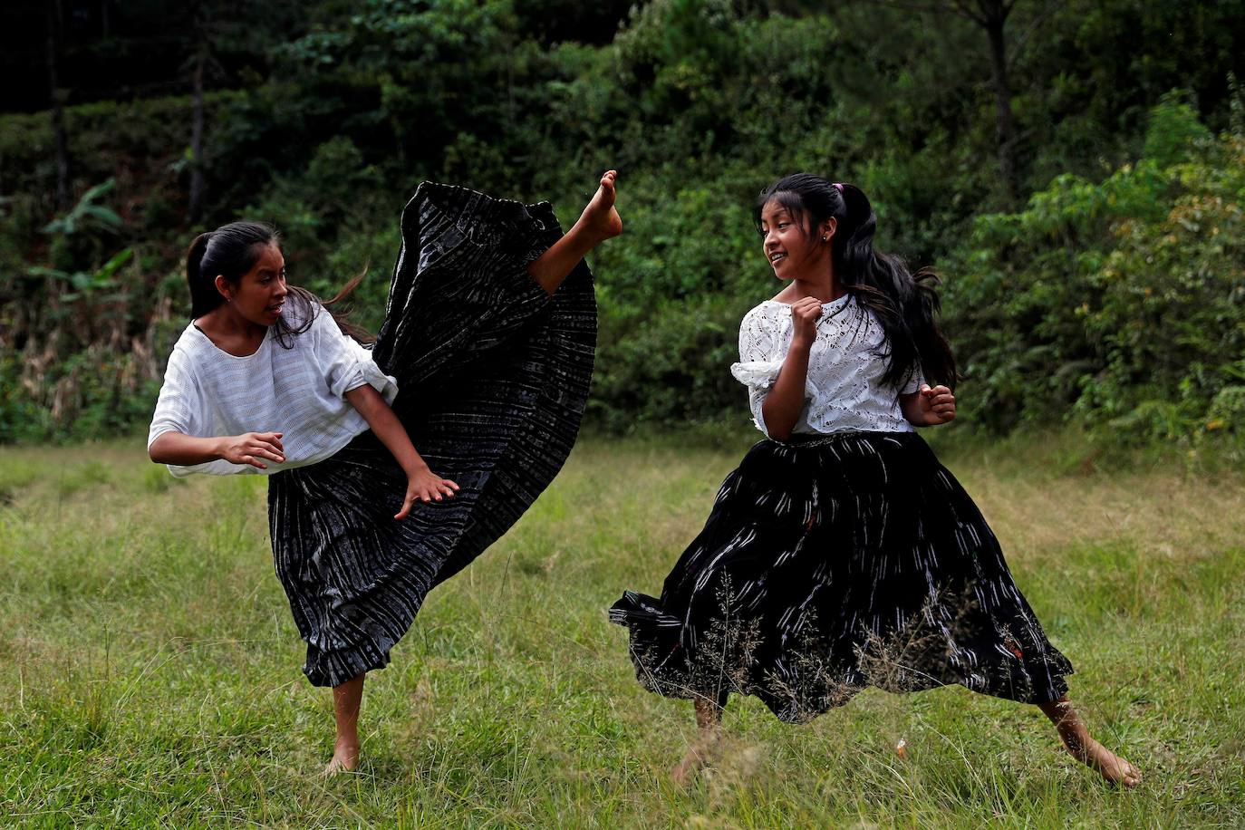 Niñas q'qchí de la aldea Tipulcan en San Pedro Carchá practican taekwondo con su maestro, Danny Coy, en una cancha de tierra en el medio de la aldea. Cada golpe es seguido por un fuerte grito que se resuena en las laderas de la zona montañosa de Alta Verapaz, en el norte de Guatemala. Con cada patada al aire, las niñas de la aldea Tipulcan espantan a los fantasmas de la violencia machista y el acoso que han sufrido en su comunidad. 