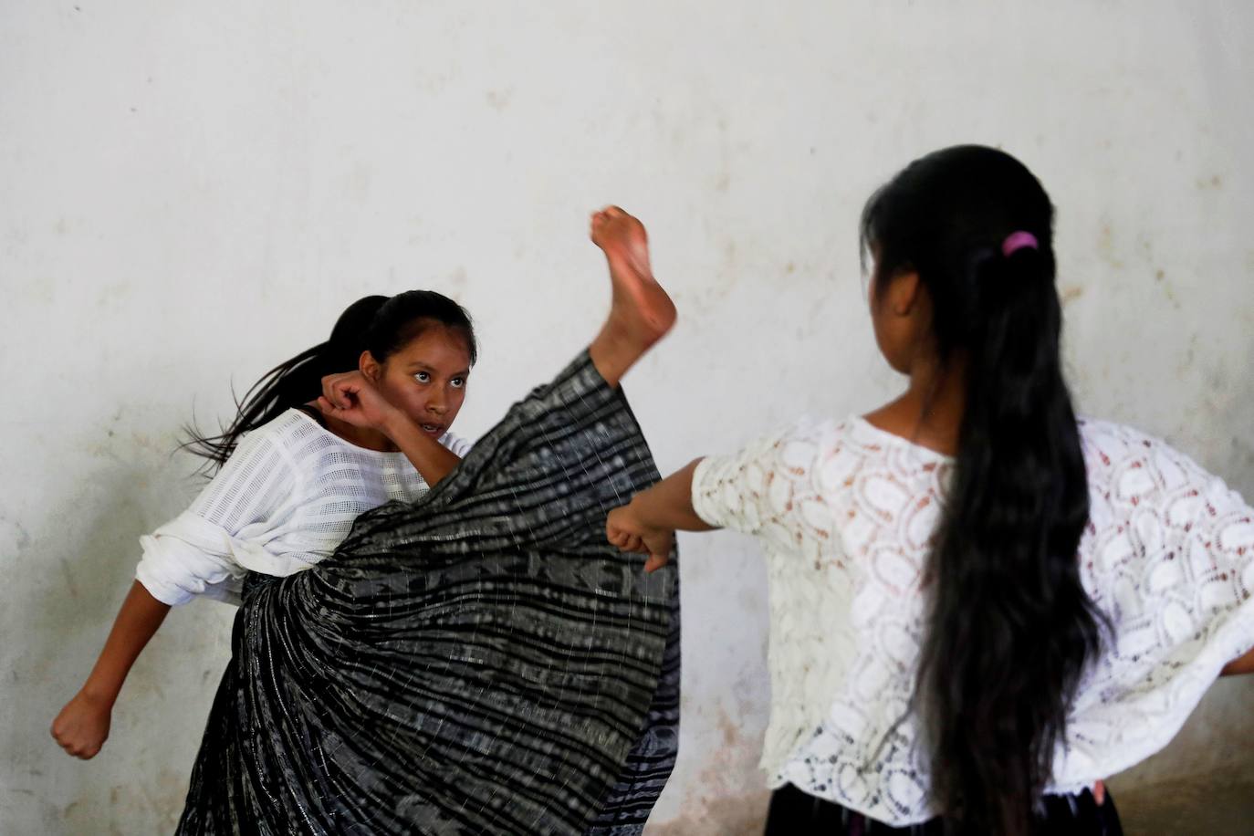 Niñas q'qchí de la aldea Tipulcan en San Pedro Carchá practican taekwondo con su maestro, Danny Coy, en una cancha de tierra en el medio de la aldea. Cada golpe es seguido por un fuerte grito que se resuena en las laderas de la zona montañosa de Alta Verapaz, en el norte de Guatemala. Con cada patada al aire, las niñas de la aldea Tipulcan espantan a los fantasmas de la violencia machista y el acoso que han sufrido en su comunidad. 
