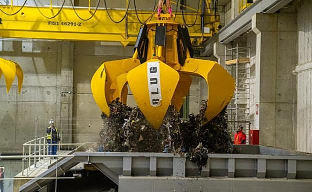 Uno de los pulpos mecánicos de la planta de valorización energética mueve las primeras toneladas de residuos que ayer fueron quemadas en Zubieta