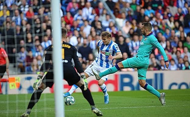 Odegaard pisa el balón para salvar la entrada de un jugador del Barcelona. 