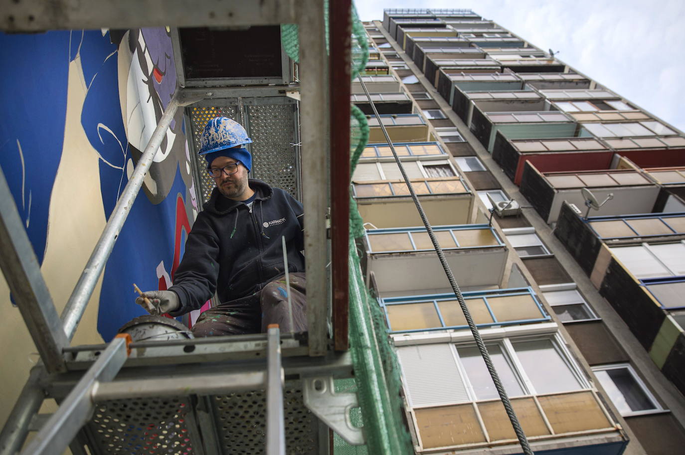 Los miembros del grupo Szines Varos (ciudad colorida) trabajan en un andamio para crear un mural en un edificio residencial en el Distrito VIII de Budapest. La obra de arte de 600 metros cuadrados representa a los personajes principales de la popular caricatura húngara Macskafogo (lit. Cat Catcher) de 1986, que se distribuyó como 'cat city' en Estados Unidos. El colectivo artístico ha realizado muchos murales a gran escala en Budapest y otras ciudades húngaras, así como en Moscú, Berlín y Londres, desde su fundación en 2008.