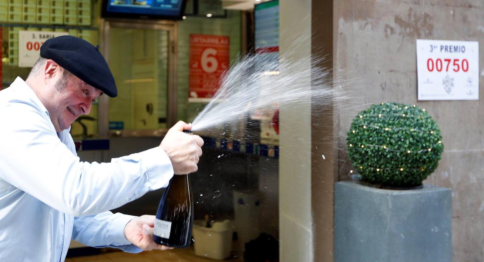 Juan Ortega Ezeiza, lotero de la administración 23 de Bilbao, abre una botella , para celebrar el reparto del tercer premio.