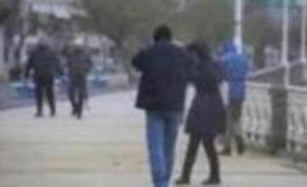 Una pareja se protege del viento este jueves en el Paseo de La Concha, en San Sebastián.