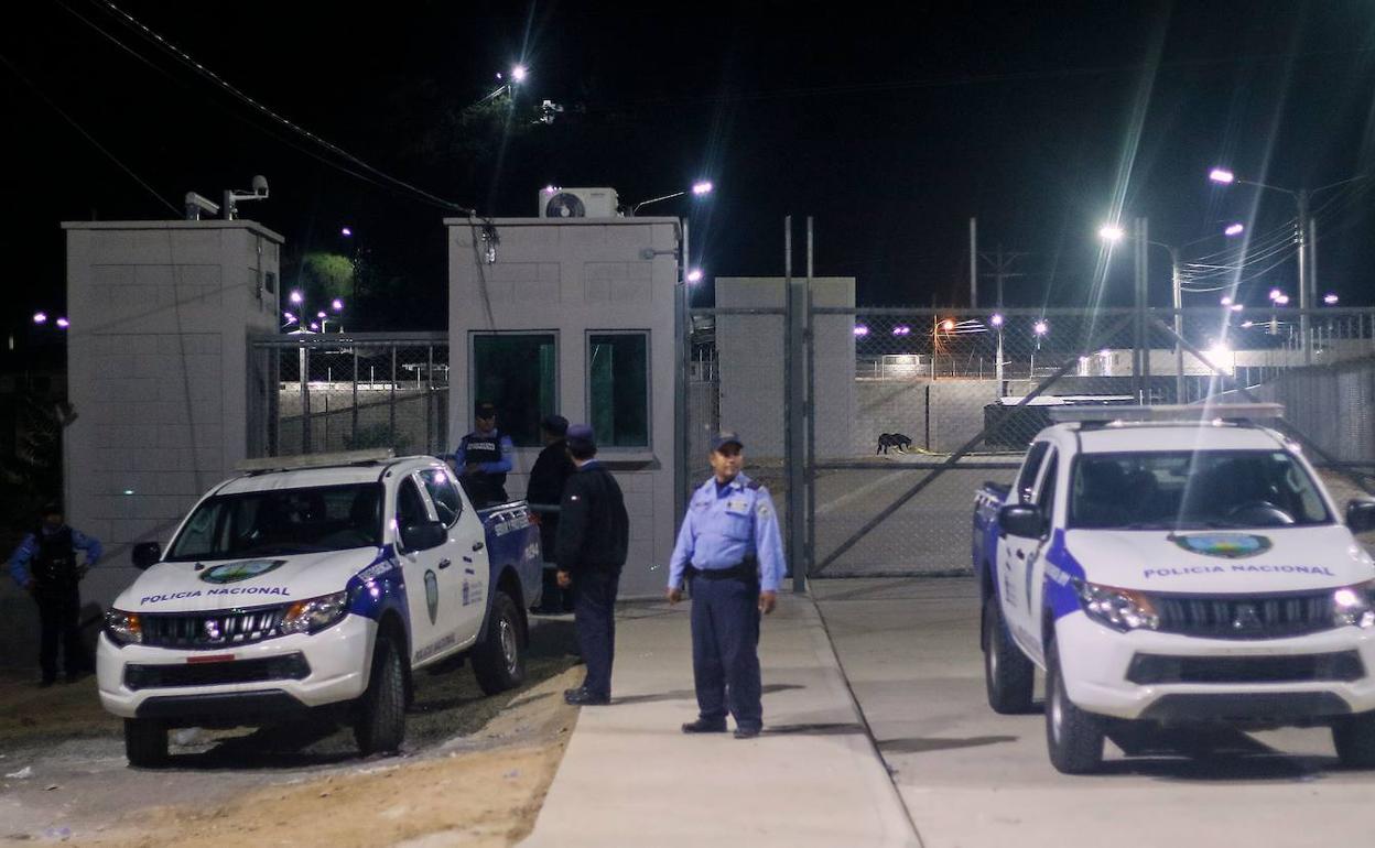 Miembros de la Policía Nacional de Honduras patrullan la entrada de la prisión de El Porvenir.