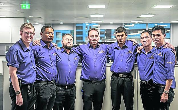 Drew Goodall, en el centro, rodeado de algunos de los trabajadores de Sunshine shoeshine.