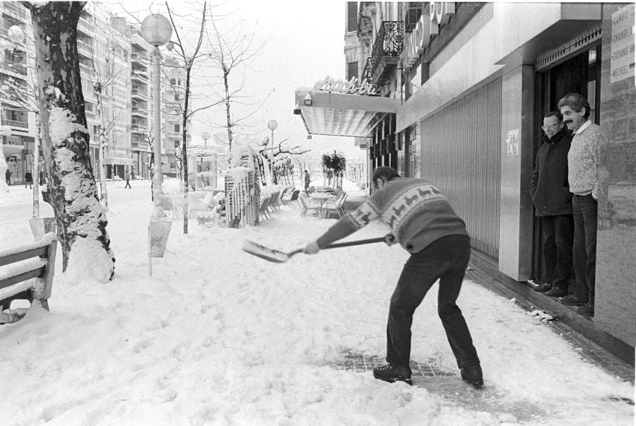 Un empleado de un banco de la Avenida retira la nieve 